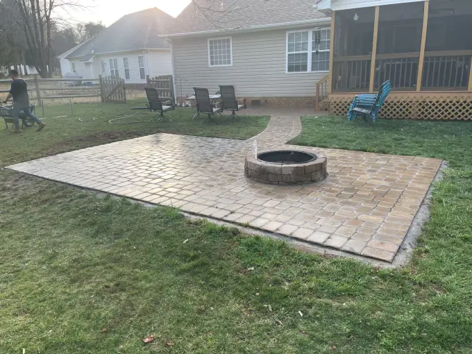 Paver patio with a fire pit positioned near a screened porch