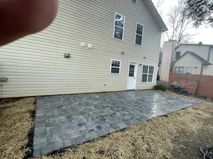Freshly laid paver patio extending along the rear of a home, ready for furniture